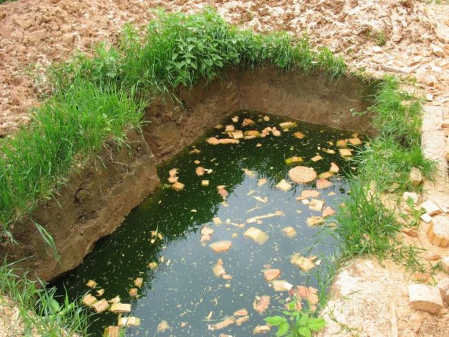 Прямоугольная яма с грунтовой водой на участке с глинистой почвой
